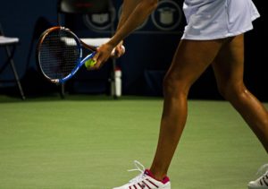 woman serves ball in tennis match